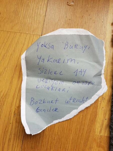 Het briefje met de bedreiging in het Turks. Het papier lijkt afgescheurd van een envelop.
