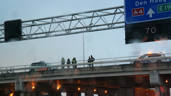 Politie en omstanders nadat het spandoek over de A4 zojuist verwijderd was.