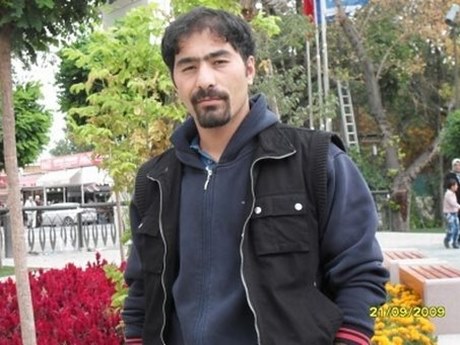 Foto van Ethem Sarisülük uit 2009. Hij staat voor een bloemperk met rode en gele bloemen. Hij draagt een blauw hoodievest en een zwarte bodywarmer.