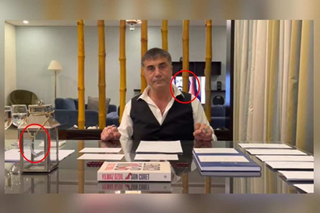Screen capture uit een video van Sedat Peker, op de achtergrond een afbeelding van de voor alevieten heilige imam Hüseyin en op de voorgrond een hanger met een zwaard, dat het zwaard van eerste imam Ali symboliseert (genaamd Zülfikar). 