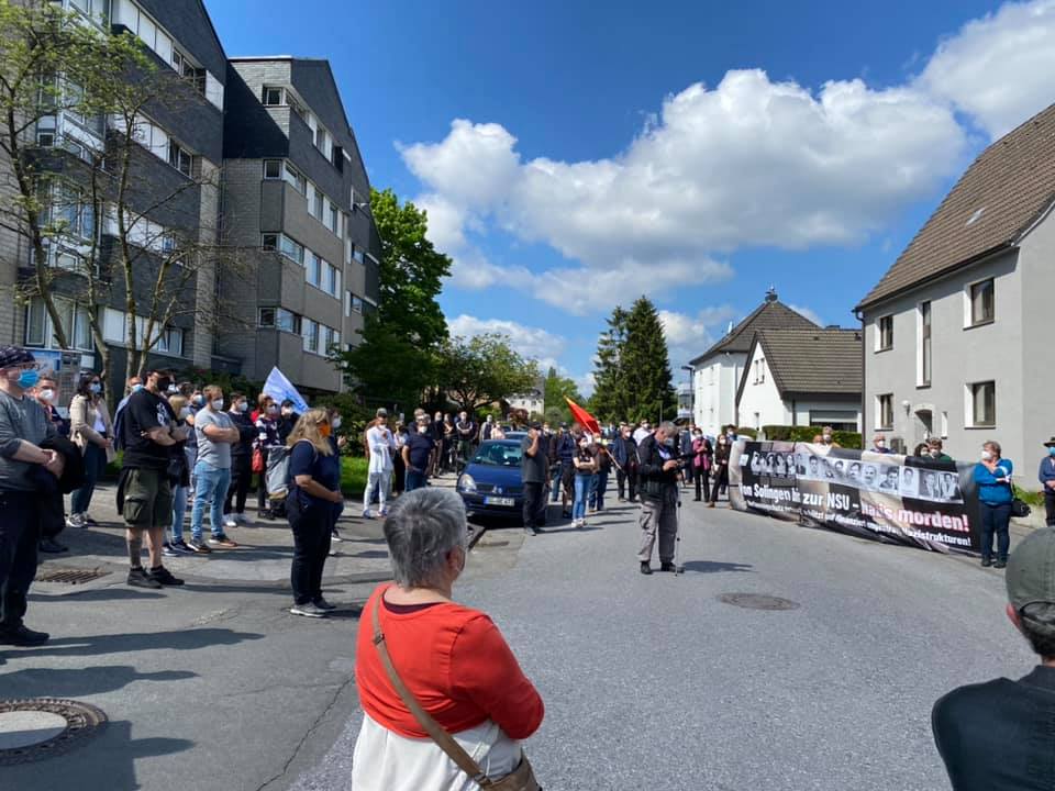 Deelnemers aan de herdenking in Solingen, met een spandoek met de foto's van de slachtoffers.