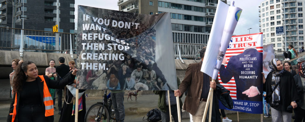 Spandoek met de tekst 'If you don't want refugees, then stop creating them'.