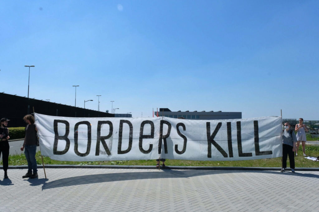 Beeld van het gigantische "BORDERS KILL" spandoek.