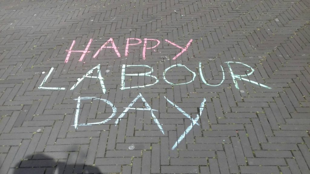 Krijttekst op straat: "Happy labour day"