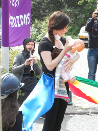 Optreden van vrouwengroep Street Amazons over hoe van alle kanten aan vrouwen getrokken wordt. Hier: zorgen voor de kinderen.