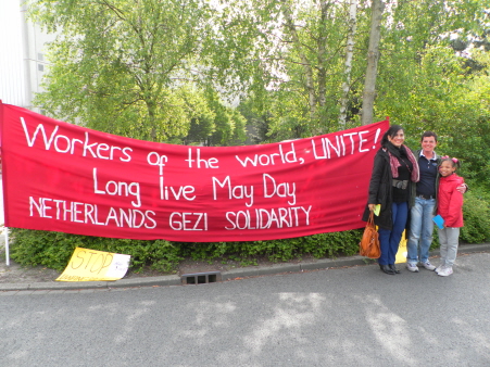 Spandoek van de groep Gezi Solidariteit Nederland, met twee solidaire SP-raadsleden er naast.