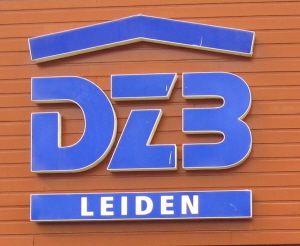 Het oude logo van DZB. Het dakje dat ooit stond voor het sociale en beschermende karakter van het bedrijf is al ruim een jaar geleden uit het logo verwijderd. (Hier werden we onlangs door een kritische medewerker op gewezen.)