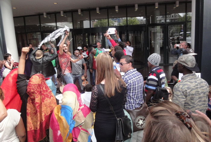 Bij het stadhuis: "Down down IND, welcome welcome refugees!"