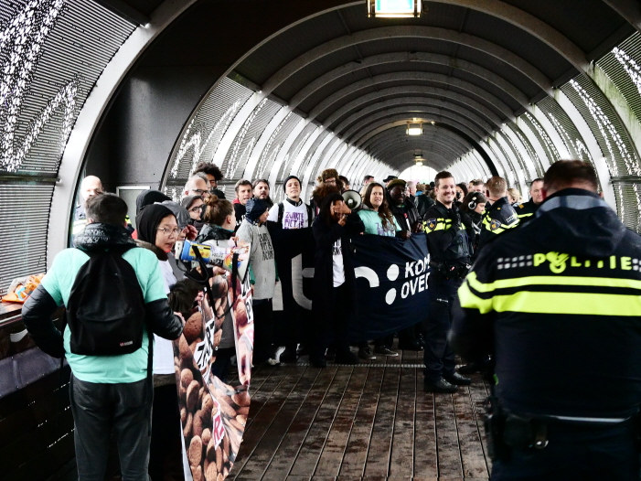 Beide groepen actievoerders bijeen op de loopbrug nadat de politie rechts een doorgang had gemaakt (foto: Jeroen van Wisse)