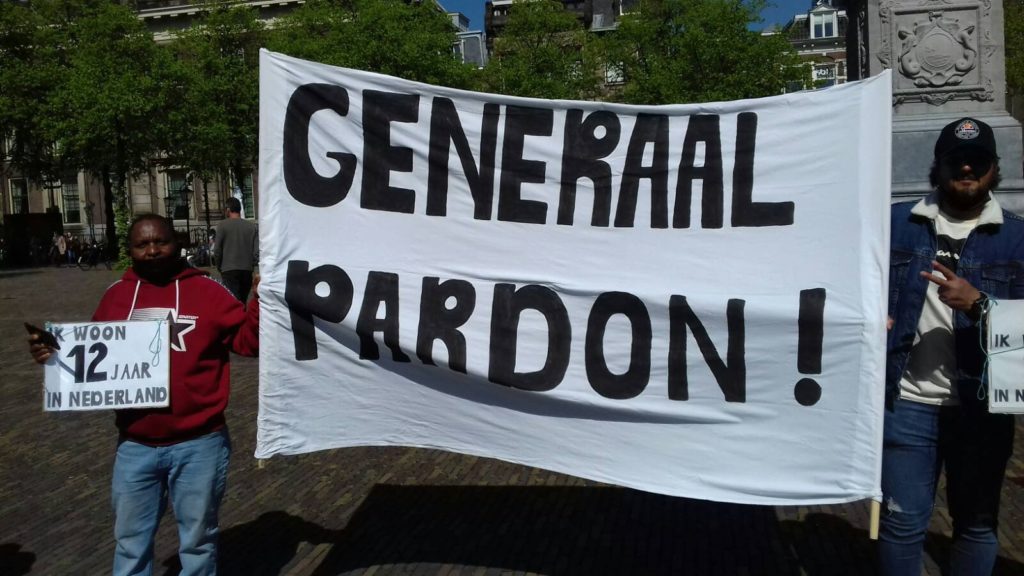 Twee demonstranten met een spandoek met de tekst "Generaal pardon!".