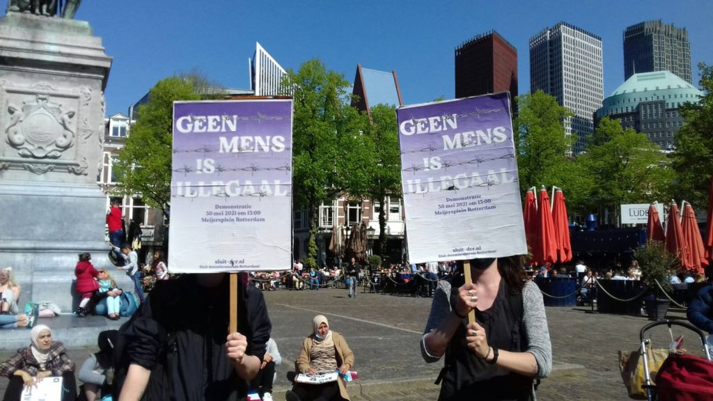 Deelnemers met "Geen mens is illegaal"-borden.