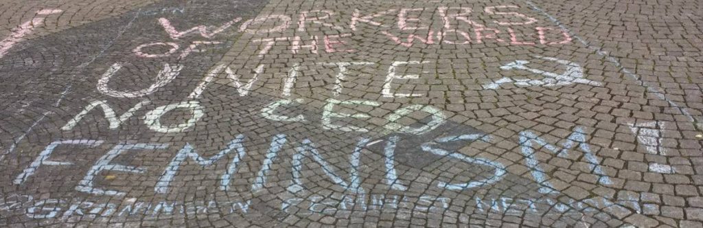 Krijttekst op kinderkopjes: "Workers of the world unite, no CEO feminism"