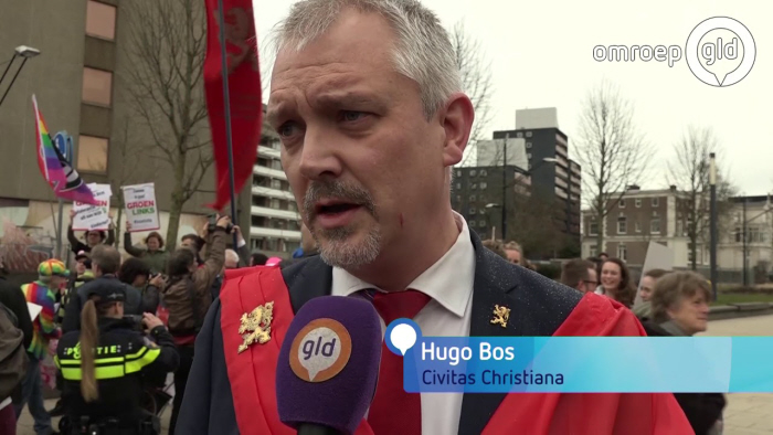 Civitas-baas Hugo Bos bij het protest in NIjmegen, links op de achtergrond de tegendemonstranten.