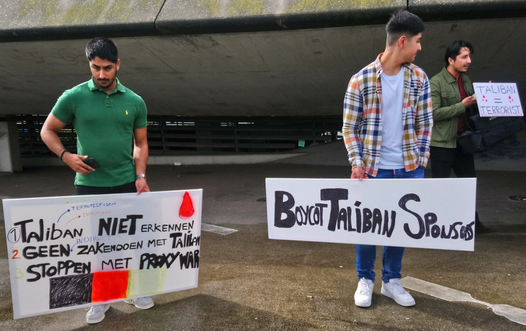 Drie demonstranten, elk met een eigen bord: '1 - Taliban niet erkennen / 2 - geen zaken doen met Taliban / 3 - stoppen met proxy war', 'Boycot Taliban sponsors' en 'Taliban = terrorist'.