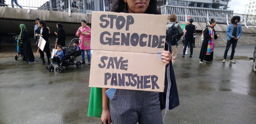 Protestbord met de tekst 'Stop genocide - save Panjsher'.