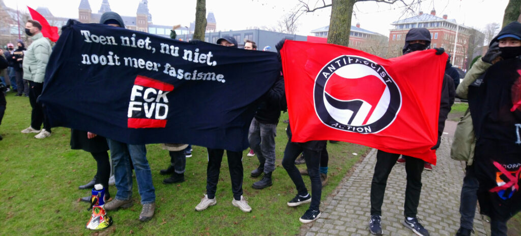 Enkele anti-fascistische demonstranten. Twee tonen een spandoek met de tekst 'toen niet, nu niet, nooit meer fascisme, fuck FVD'.

