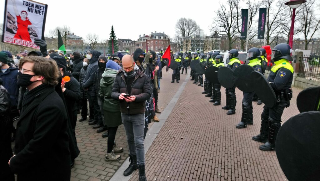 Een groep antifascistische demonstranten, omsingeld door mobiele eenheid.