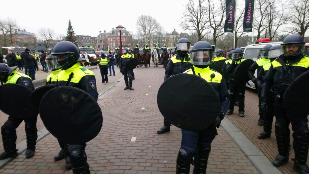 Een stuk of twintig M.E.-ers met schilden en knuppels.