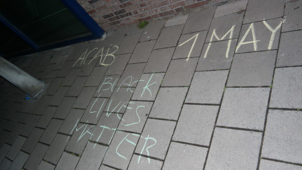 Krijttekst op straat: "ACAB - Black Lives Matter - 1 mei"