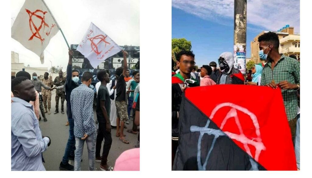 Linker afbeelding. Een groep demonstranten. Twee demonstranten wuiven anarchy vlaggen. Op de achtergrond zijn militairen te zien.

Rechter afbeelding. Op een demonstratie houden twee demonstranten een rood met zwarte anarchy vlag vast.