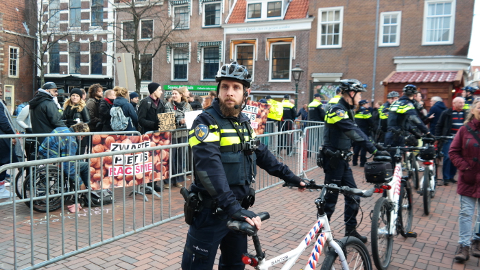 Ons 'vak' met twee rijen hekken en een linie fietsagenten er voor.