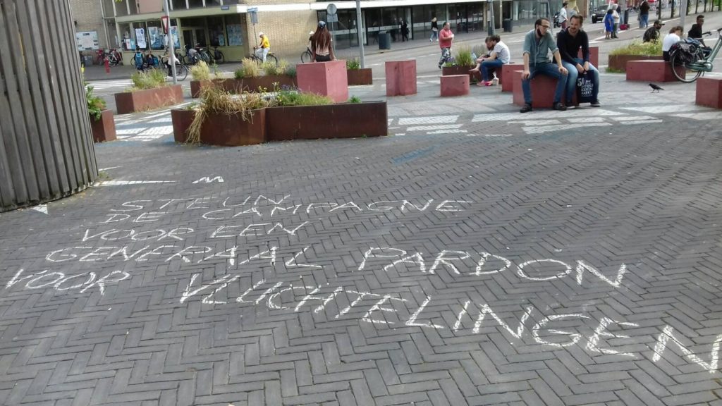 Leus op de grond "Steun de campagne voor een generaal pardon voor vluchtelingen".