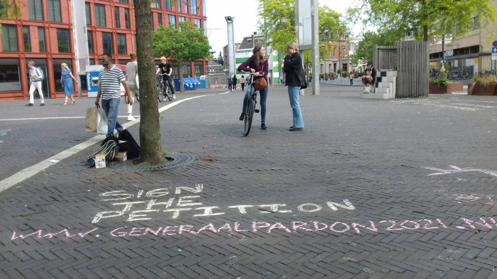 Leus op de grond bij Leiden Centraal: Sign the petition - www.generaalpardon2021.nl".