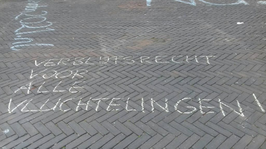 Leus op de grond "Verblijfsrecht voor alle vluchtelingen".