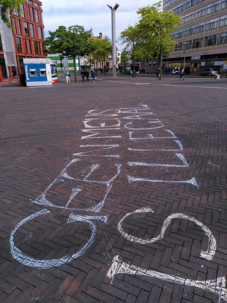 Leus op de grond in sierlijke letters "Geen mens is illegaal".