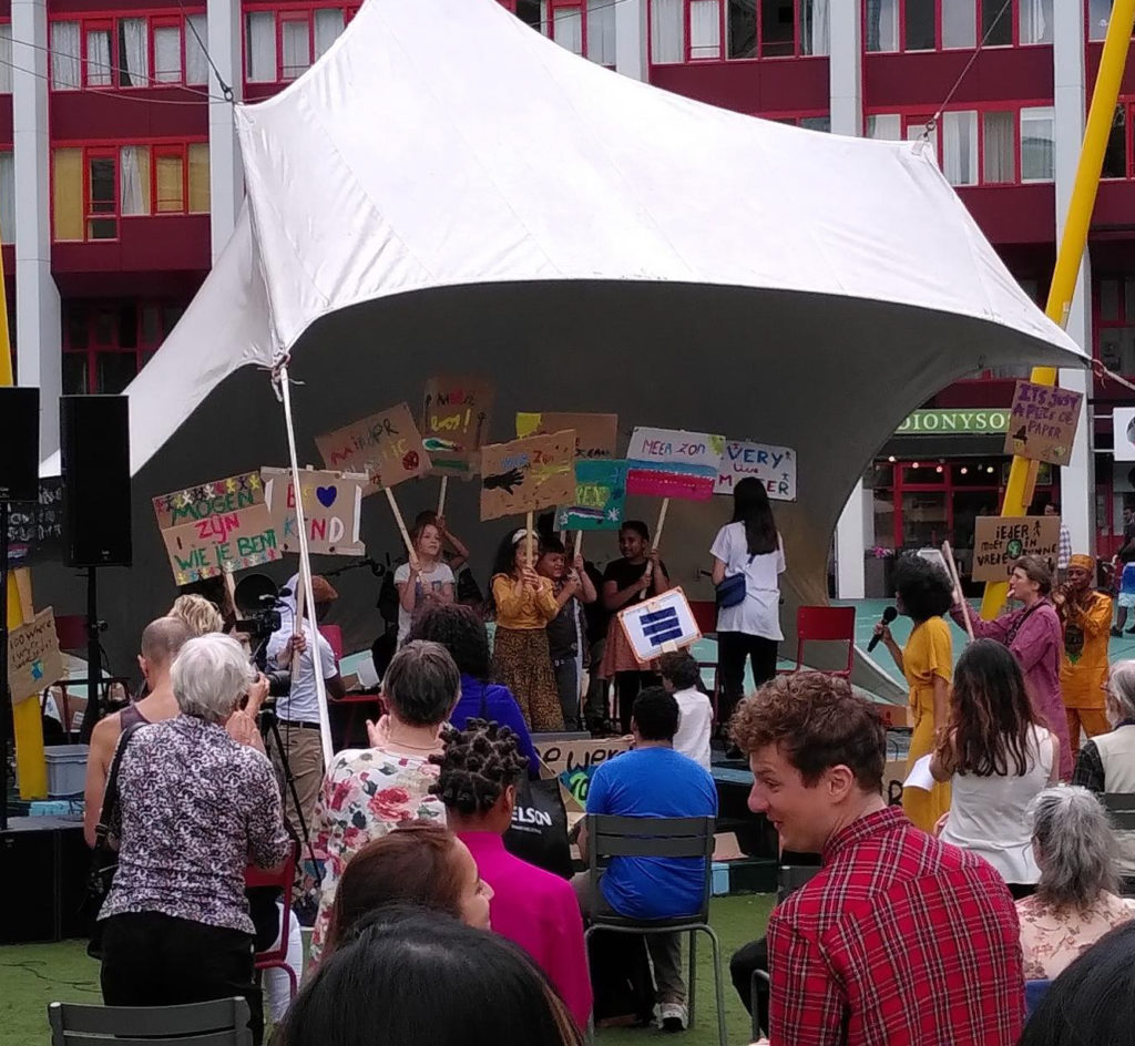 De kinderen op het podium met hun zelfgemaakte borden.