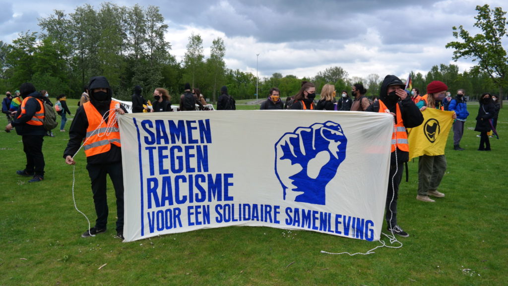 Twee activisten met het spandoek "Samen tegen racisme - voor een solidaire samenleving".