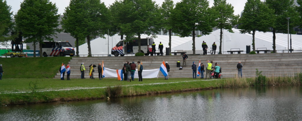 De 15 nazi's met hun NSB-/Prinsenvlaggen. Ze staan flink voor lul met hun sneue groepje.