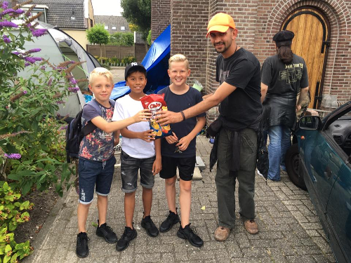 Drie jongetjes komen een zak chips brengen voor de vluchtelingen in Wormer.